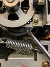 The alignment holes for the cam pulley are marked with white dots (with the screwdriver pointing to the hole in the pulley itself). In this case the holes are near alignment, so only a fine adjustment is needed.