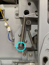 The separator spring, which should be detached at the marked point (and/or fully removed).