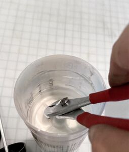 Pliers are used to grab a fin of the plunger and pry it out.