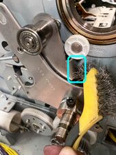 A bristle brush is used to clean the indicated surface (which makes contact with the shock absorber when this arm is lowered (sand paper will also work).